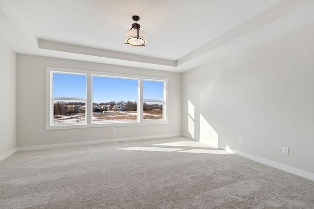 empty room featuring carpet and baseboards