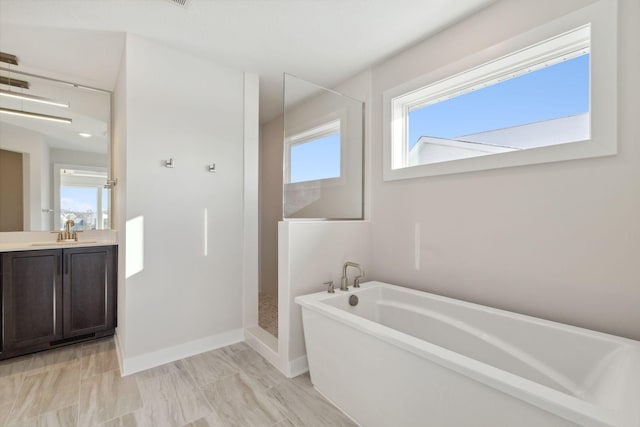 full bathroom featuring a soaking tub, baseboards, walk in shower, and vanity