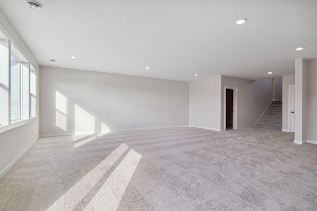 unfurnished living room featuring stairs, light carpet, baseboards, and recessed lighting