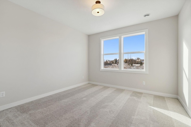 unfurnished room with light carpet and baseboards