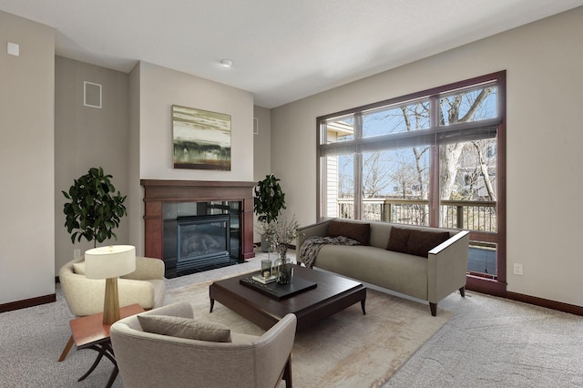 living area featuring a tiled fireplace, visible vents, baseboards, and carpet floors