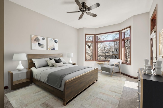 bedroom featuring baseboards, light colored carpet, and ceiling fan