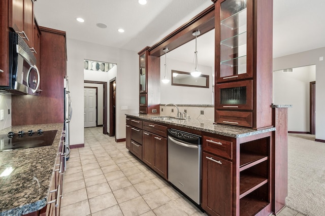 kitchen with glass insert cabinets, decorative light fixtures, decorative backsplash, stainless steel appliances, and a sink