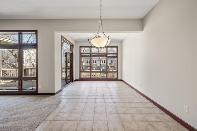 unfurnished dining area featuring light tile patterned flooring, a healthy amount of sunlight, and baseboards