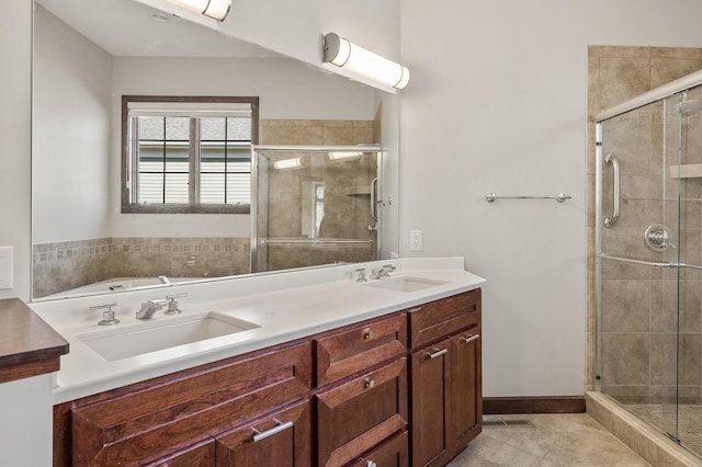 full bathroom featuring a sink, visible vents, a shower stall, and tile patterned flooring