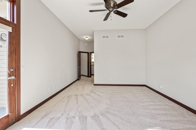 carpeted empty room with baseboards, visible vents, and ceiling fan