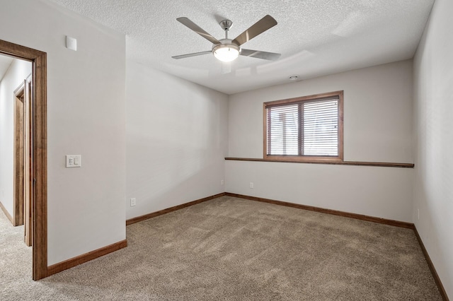 empty room with baseboards, carpet, ceiling fan, and a textured ceiling