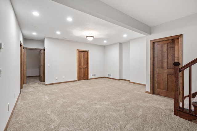 basement with stairway, recessed lighting, light colored carpet, and visible vents