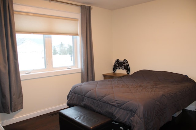 bedroom with baseboards and wood finished floors