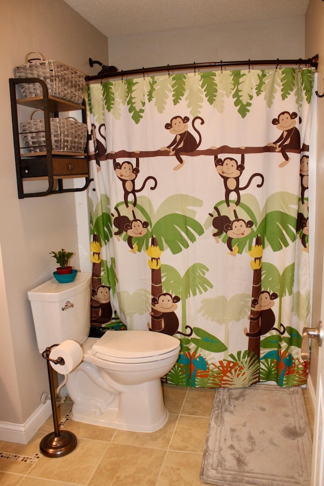 bathroom featuring toilet, curtained shower, a textured ceiling, and tile patterned floors