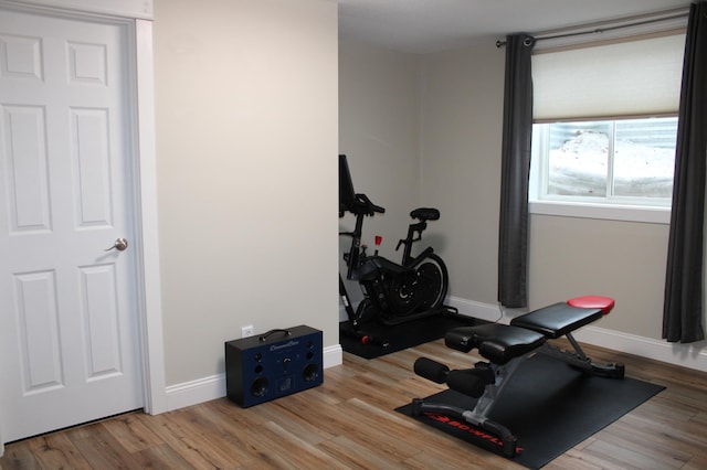 exercise room featuring baseboards and wood finished floors