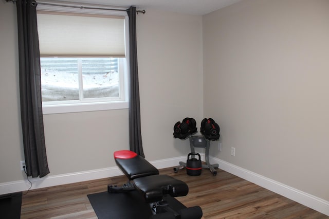 workout room featuring baseboards and wood finished floors