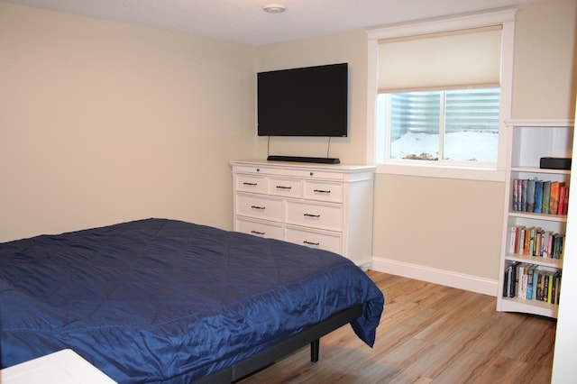 bedroom featuring light wood-style flooring and baseboards