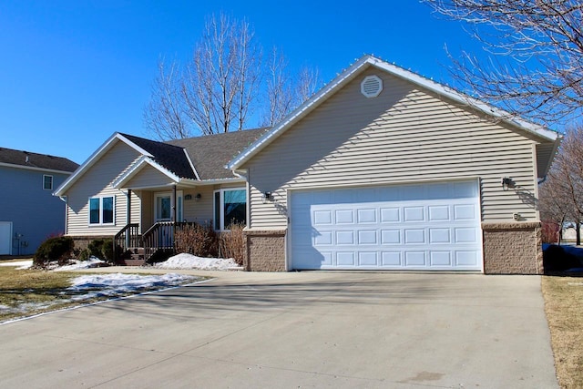 ranch-style home with concrete driveway, brick siding, and an attached garage