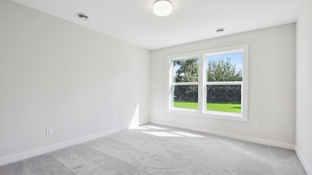 carpeted spare room featuring visible vents and baseboards