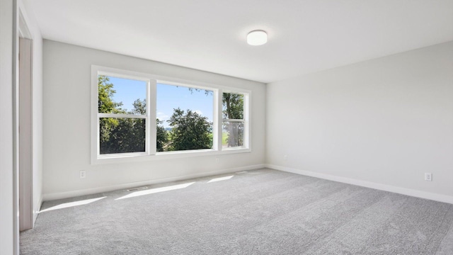 carpeted spare room with baseboards