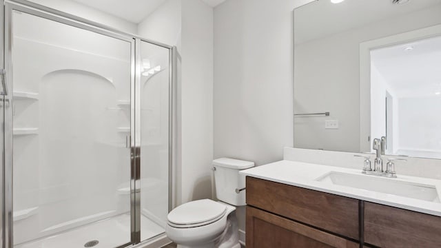 full bathroom featuring a stall shower, vanity, and toilet