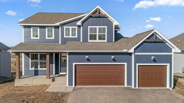 view of front of property with a porch, roof with shingles, board and batten siding, and driveway