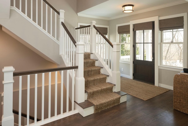 foyer featuring wood finished floors, stairway, ornamental molding, and baseboards