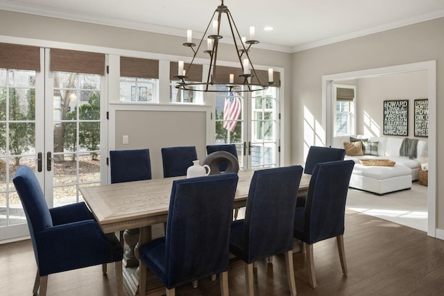 dining room featuring a chandelier, plenty of natural light, french doors, ornamental molding, and wood finished floors