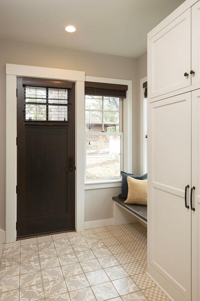 foyer featuring baseboards, recessed lighting, and light flooring