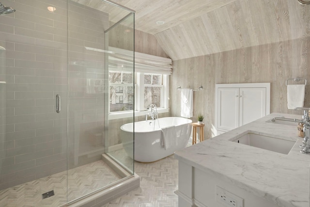 full bathroom with a stall shower, lofted ceiling, a freestanding bath, and vanity