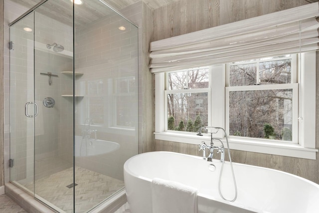 bathroom with a stall shower and a freestanding bath
