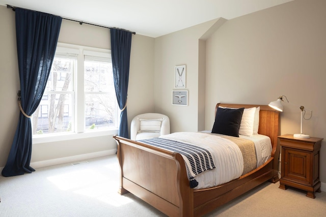 bedroom featuring light colored carpet and baseboards