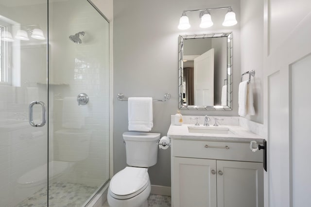full bathroom featuring a shower stall, toilet, and vanity