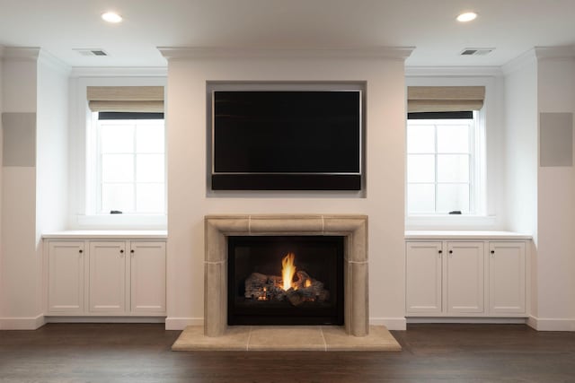 detailed view of ornamental molding, wood finished floors, recessed lighting, a tile fireplace, and baseboards