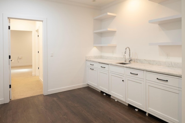 bar with a sink, dark wood-style flooring, crown molding, and baseboards