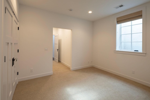 unfurnished bedroom with light colored carpet, baseboards, and recessed lighting