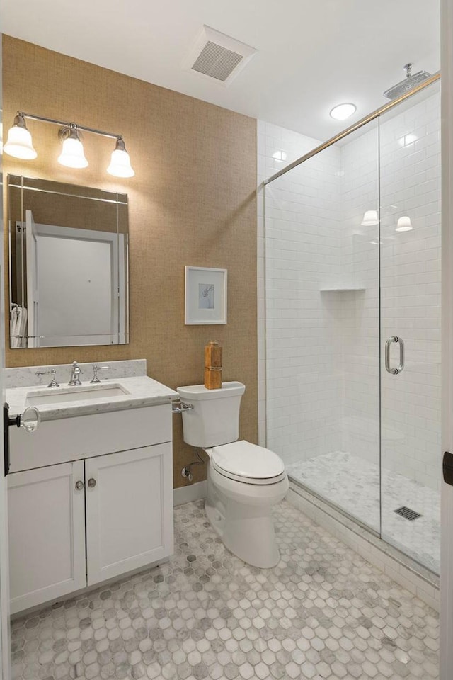 bathroom with a stall shower, toilet, and vanity