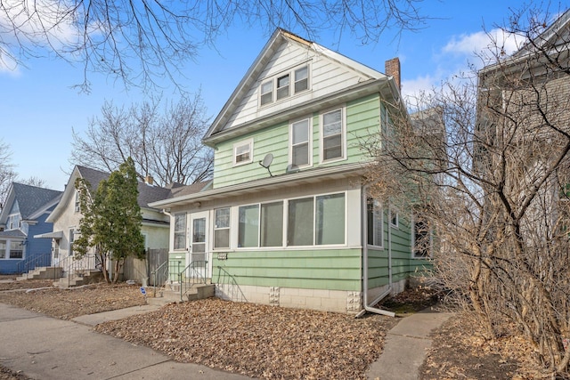 american foursquare style home featuring a chimney