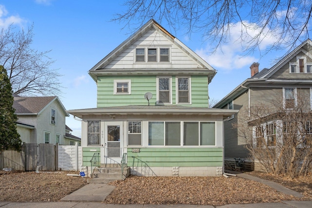 american foursquare style home featuring entry steps and fence