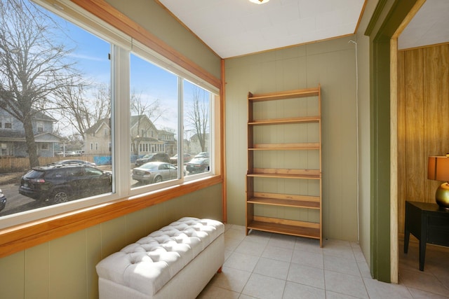 sitting room featuring tile patterned floors, a residential view, and wooden walls