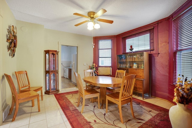 dining room featuring ceiling fan, light tile patterned floors, visible vents, and a textured ceiling