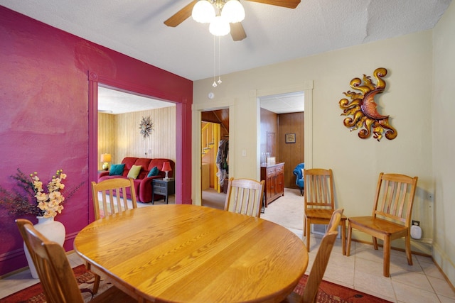 dining area featuring light tile patterned flooring, baseboards, a textured ceiling, and a ceiling fan