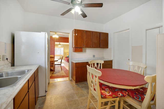 kitchen featuring brown cabinets, light countertops, and freestanding refrigerator