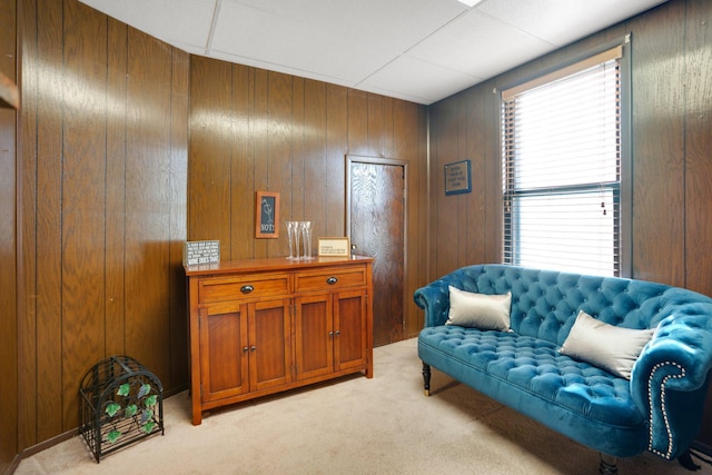 sitting room with light colored carpet and wood walls