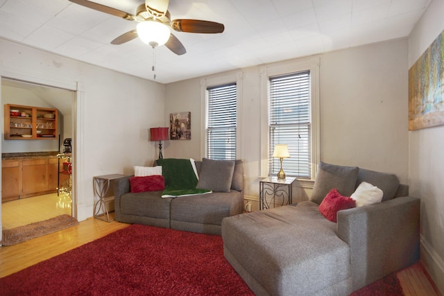 living area featuring light wood-type flooring and ceiling fan