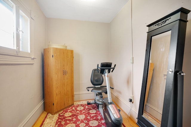 workout room featuring baseboards and wood finished floors