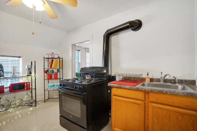 kitchen featuring light floors, a sink, vaulted ceiling, black range with gas cooktop, and brown cabinets