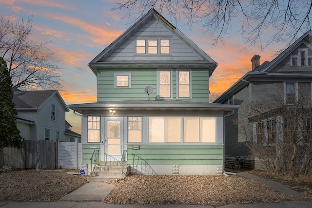 view of front of home featuring entry steps and fence