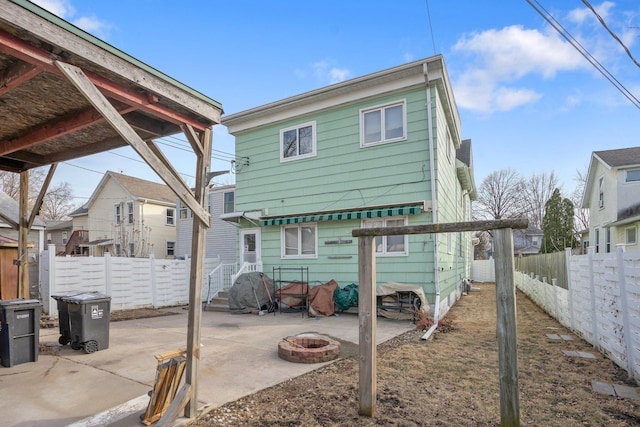 rear view of property with a patio, fence, and an outdoor fire pit