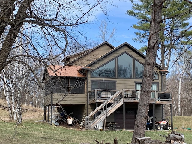 rear view of house with stairway, a deck, and a yard