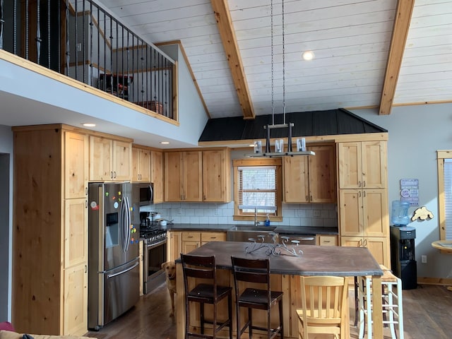 kitchen with dark countertops, appliances with stainless steel finishes, dark wood-style flooring, and beamed ceiling