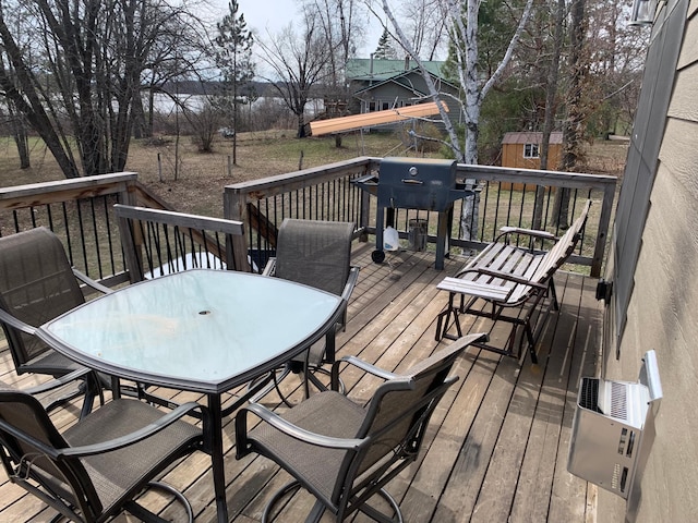 deck featuring outdoor dining area and a grill