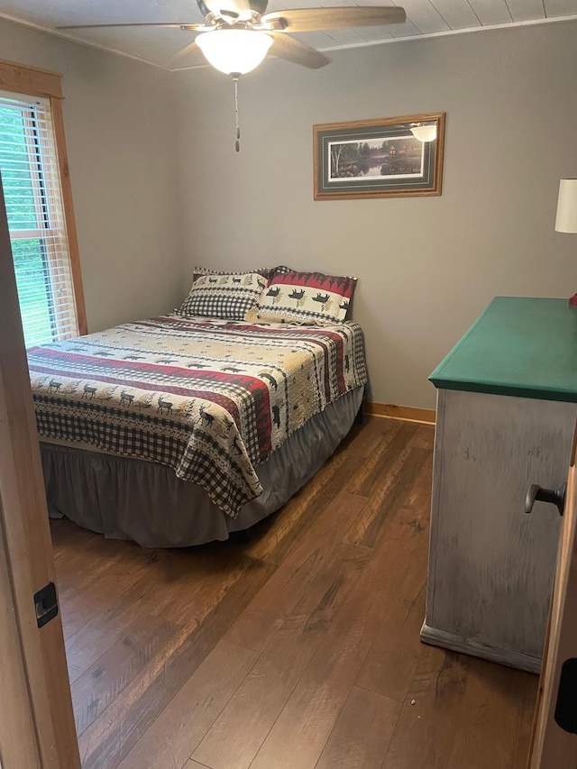 bedroom featuring wood-type flooring, baseboards, and ceiling fan