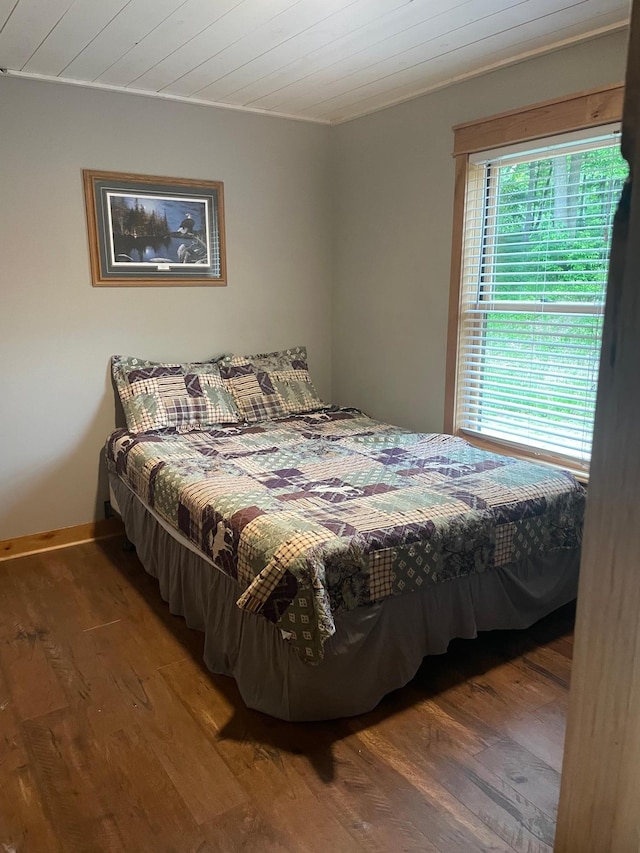 bedroom featuring wooden ceiling, baseboards, and wood finished floors